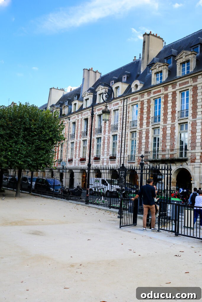 A beautiful row of virtually identical private residences at the Place des Vosges in the Marais, Paris, showcasing subtle architectural variations.