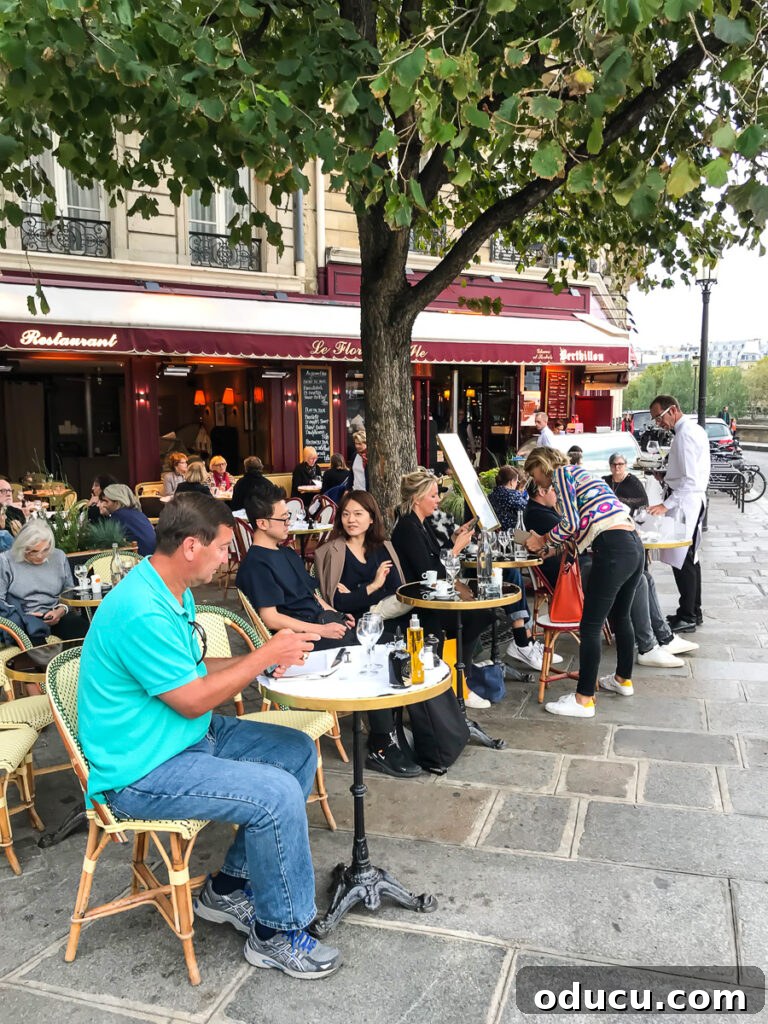 Enjoying a delightful dinner at a charming cafe along the picturesque Seine River in Paris, with boats passing by.