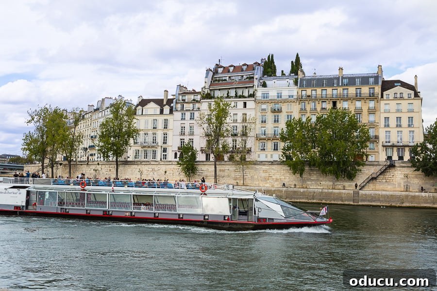 Another tourist boat elegantly navigating the Seine River in Paris at night, contributing to the magical ambiance of the illuminated city.
