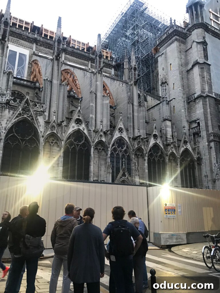 An up-close view of Notre Dame Cathedral following the fire, highlighting the extensive damage and ongoing recovery efforts, including structural supports.