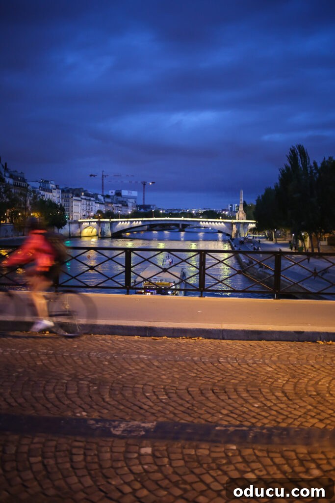 Cycling through the charming St. Germain district in Paris at night, enjoying the well-lit bike path and picturesque surroundings.