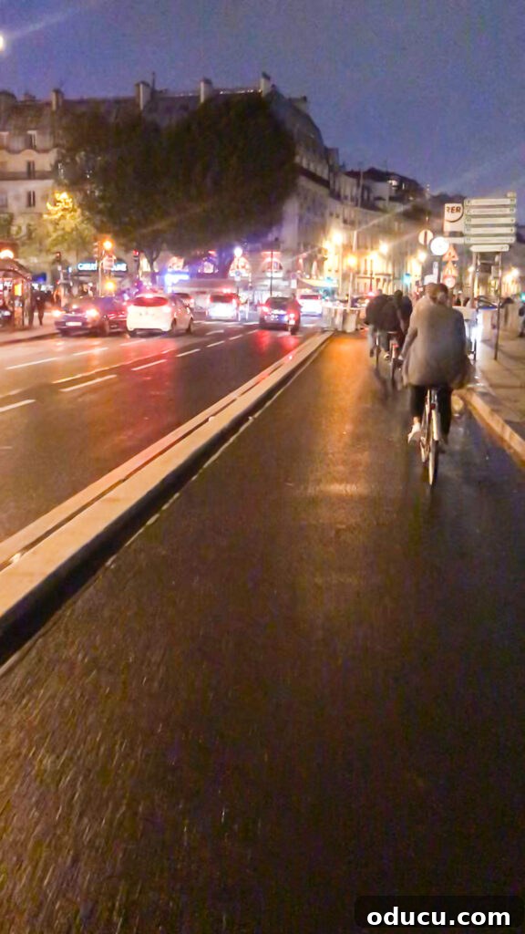 Riding bikes at night in Paris along the designated bike path in the charming St. Germain neighborhood, offering a safe and scenic journey.
