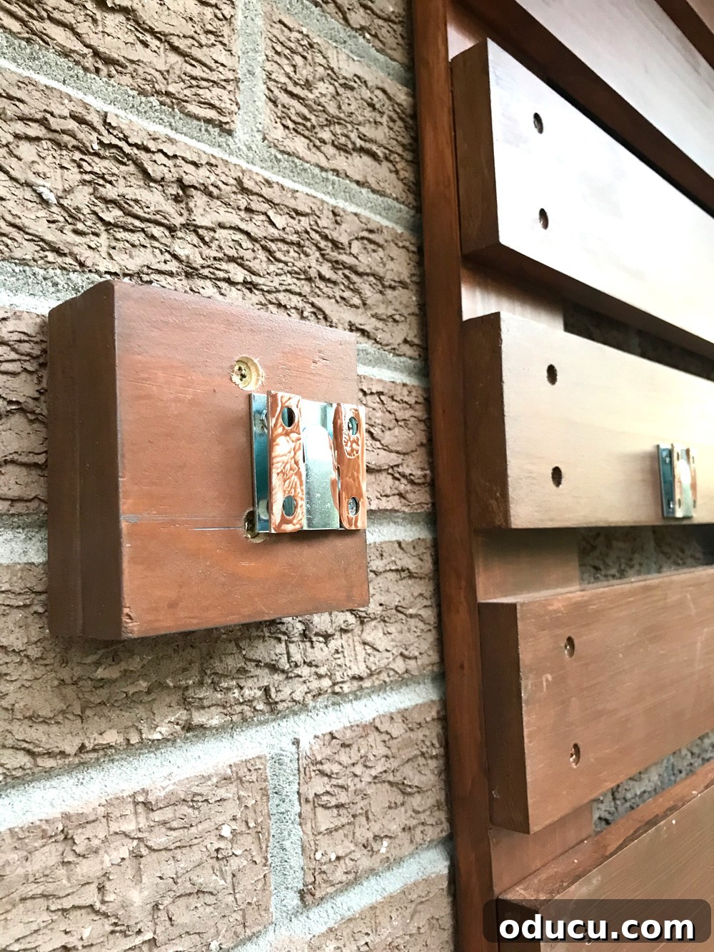 Close-up of a wall-mounted hanger with paint dabbed on it, ready to transfer marks for precise alignment.