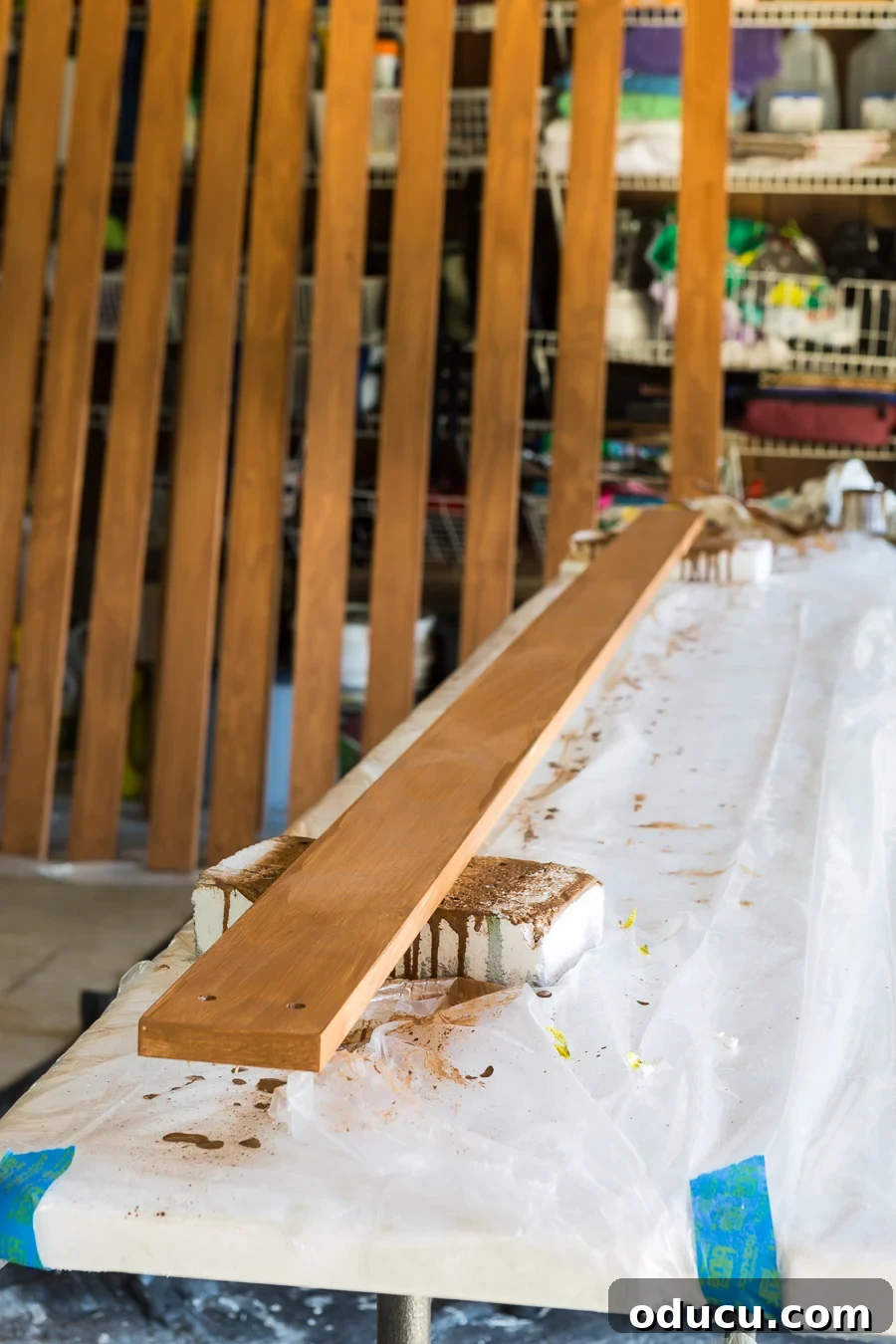 How to stain wood slats to create a modern wood slat accent wall, demonstrating thorough application.