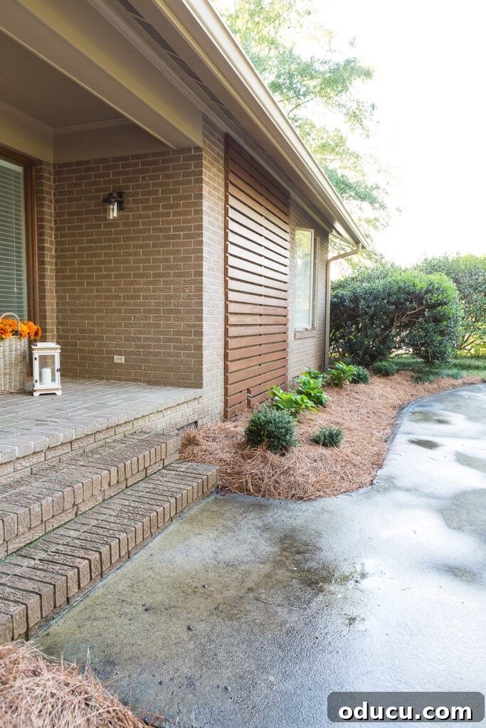Wood slat wall ideas outdoor on a home's facade, showcasing effective attachment to brick.