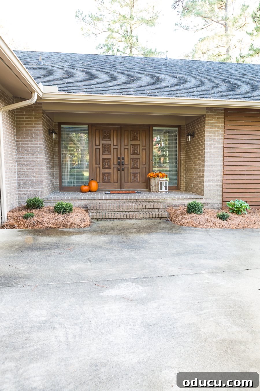 Front entry of a 1970's ranch home that is getting a budget modern makeover, showcasing the new wood slat wall.