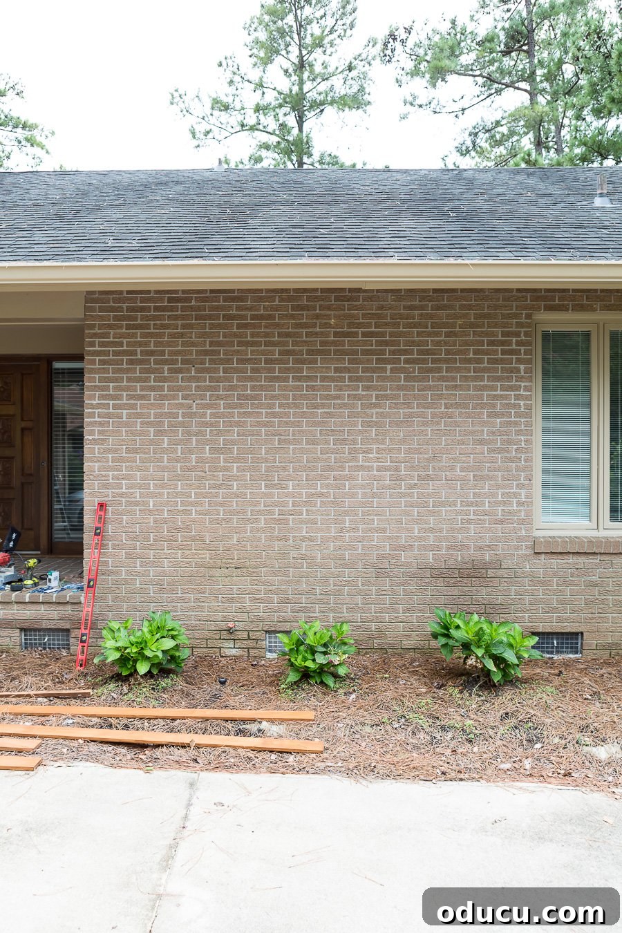 Before photo of plain brick Ranch style home, illustrating the starting point for the wood slat wall project.
