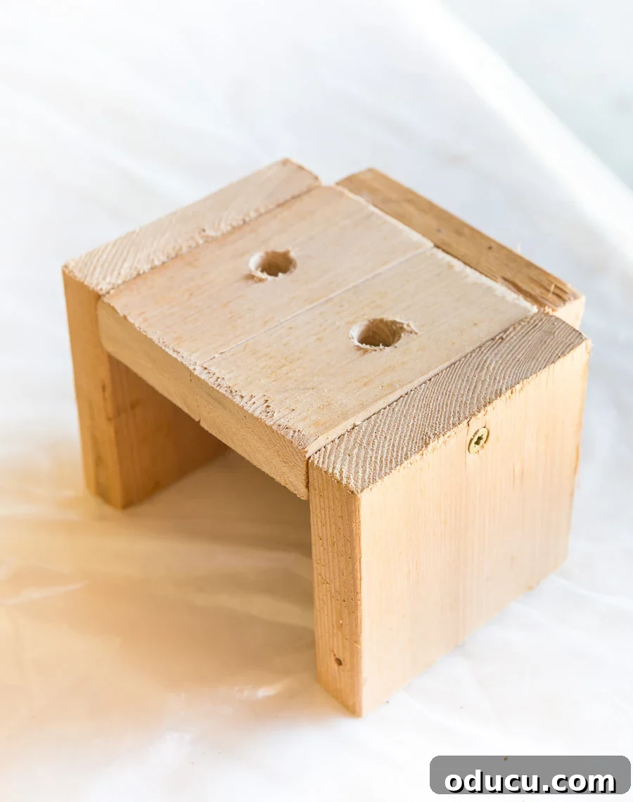 Wood jig to use when drilling holes into the end of boards to create a modern wood slat accent wall, ensuring precision.