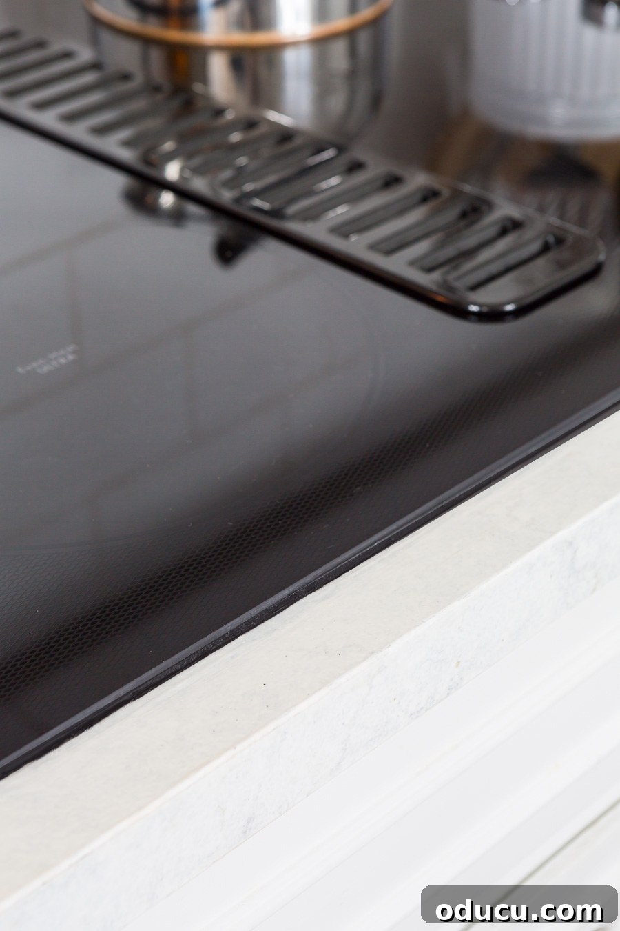 Flawless Finish: Repairing Painted Kitchen Counter Scratches and Dings 15 Kitchen with new black glass cooktop and freshly repaired white kitchen counters.