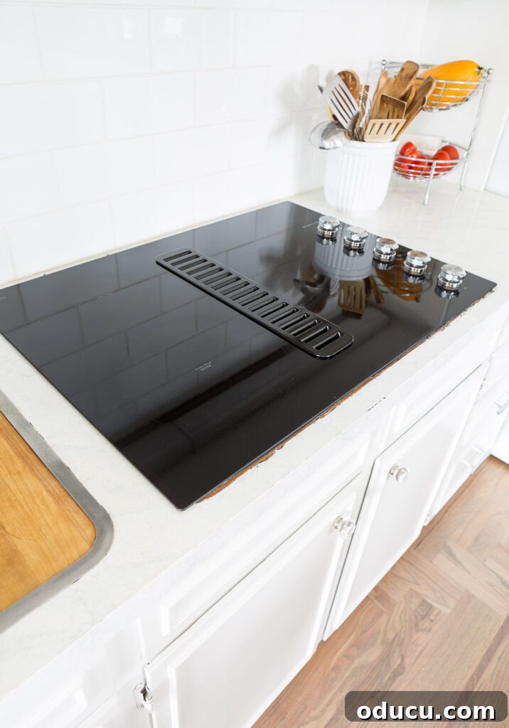 Flawless Finish: Repairing Painted Kitchen Counter Scratches and Dings 4 New black glass ceramic drop-in cooktop seamlessly integrated into the kitchen counter.
