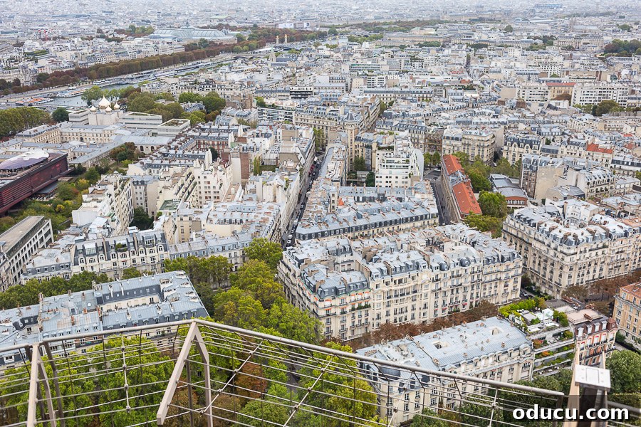Ascending Paris's Masterpiece 6 An expansive view of Paris captured from the top of the Eiffel Tower, showing a blend of historical and residential areas.