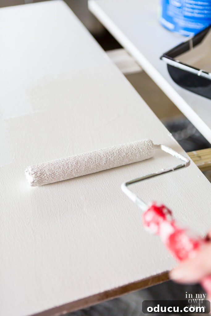 Why Primer Is Essential For Painting Over Stained Paint 9 Rolling white paint on wood shelves over a primer coat for a smooth finish.