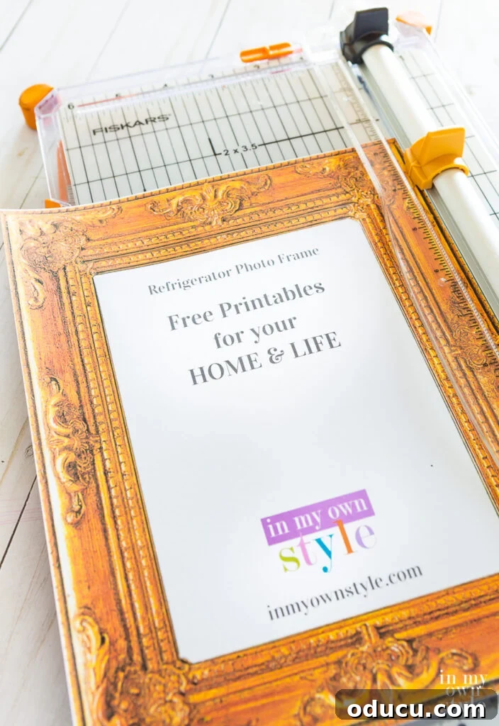 A person precisely cutting the outer edges of a free printable photo frame using a paper cutter for a clean finish.
