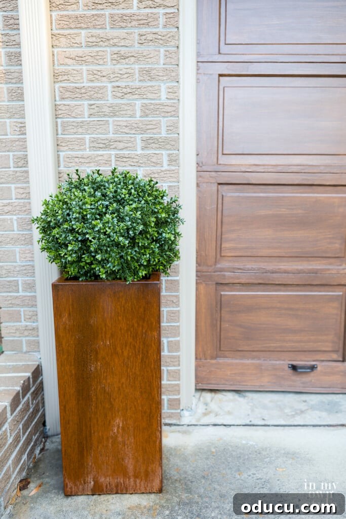 Unlock Corten's Rustic Beauty Instantly 4 A corten steel tall planter in a driveway, before treatment