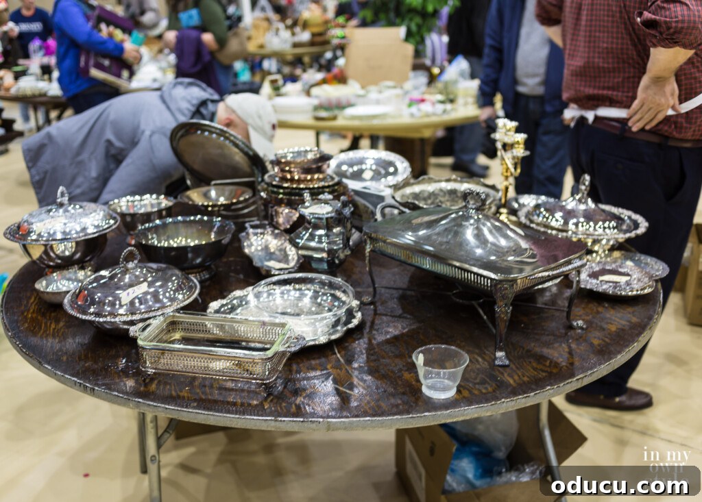 Decorating Magic for Just $23 7 An array of silver and silver-plated items glistening on a busy sales table at a bazaar.
