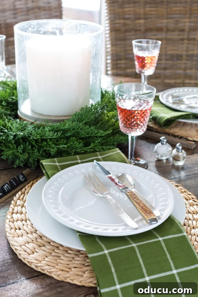 Wood-Effect Dining Table Upgrade 2 Round dining table set for a Christmas dinner using white plates and olive green napkins, featuring a dark wood bulletin board roll paper as a temporary tablecloth solution.
