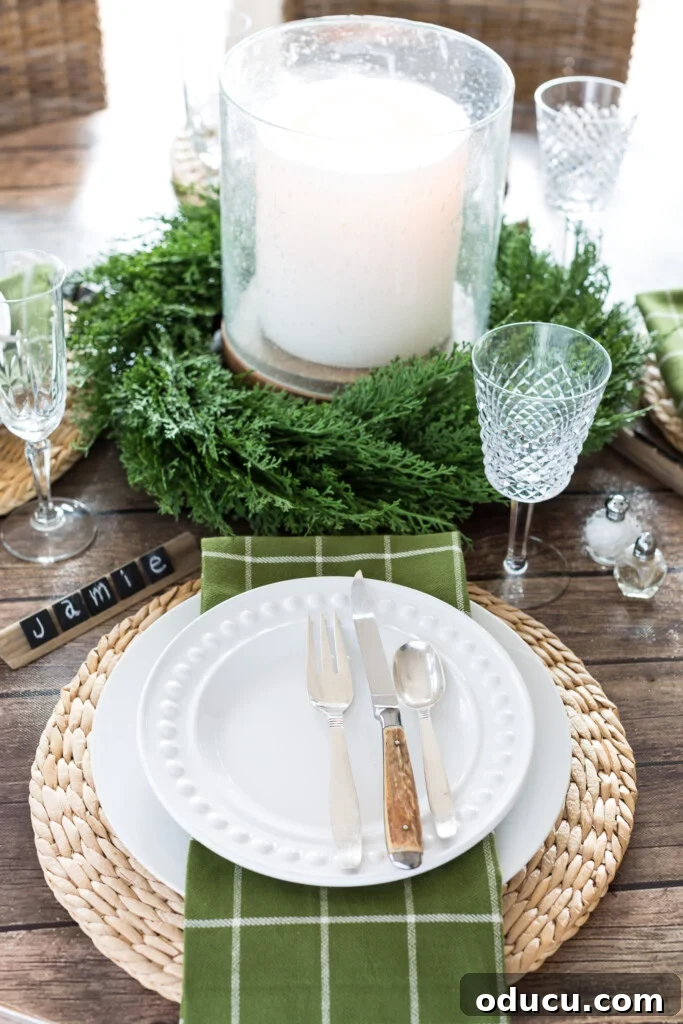 Wood-Effect Dining Table Upgrade 6 Cozy Christmas dining table setting on a temporary dark wood look table cover made from bulletin board paper, featuring a large bubble glass candle and DIY chalkboard tile place cards.
