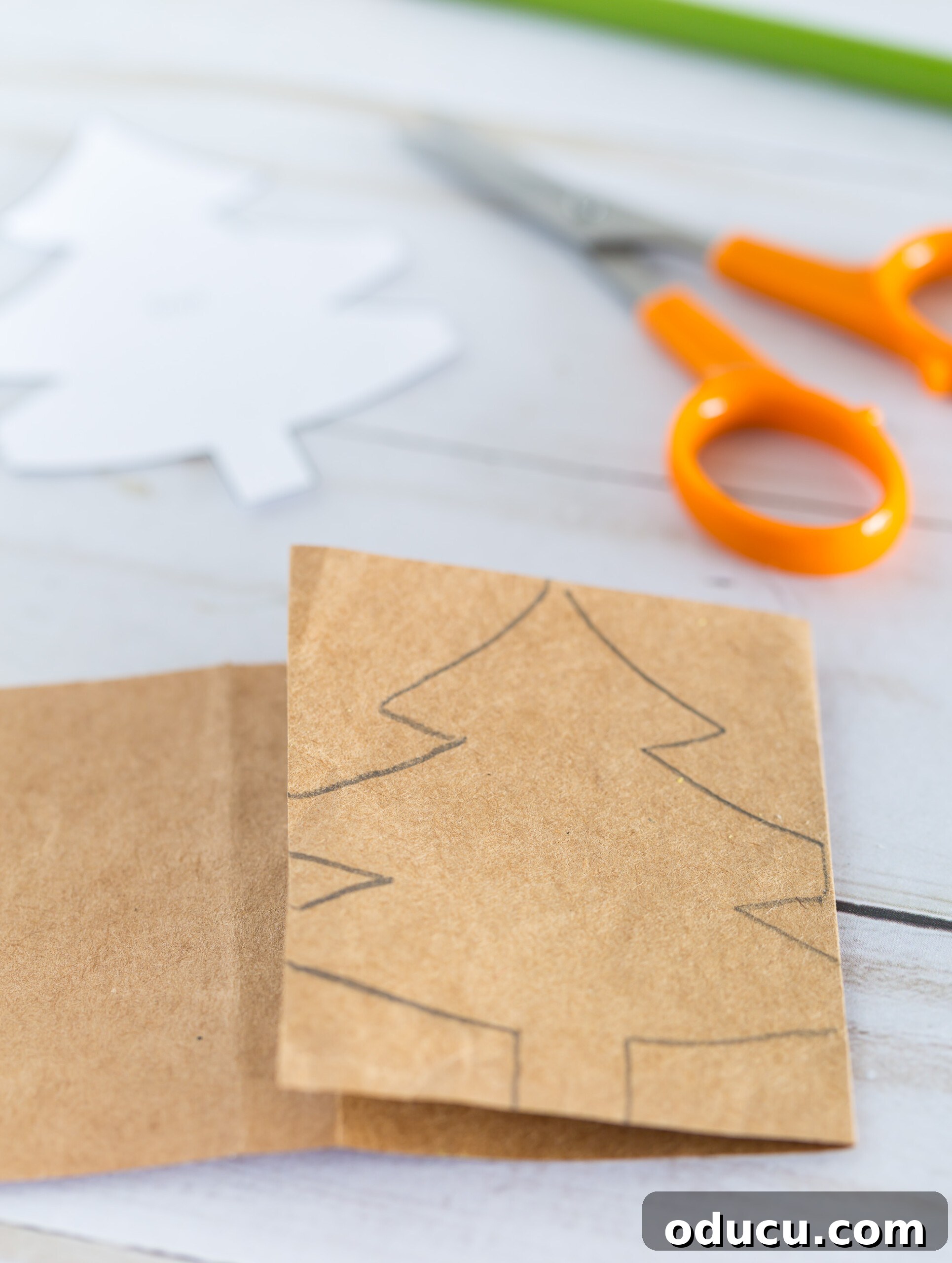 Craft Your Own Christmas Tree Paper Chain 10 How to start folding a template of a Christmas tree pattern on to a strip of paper.
