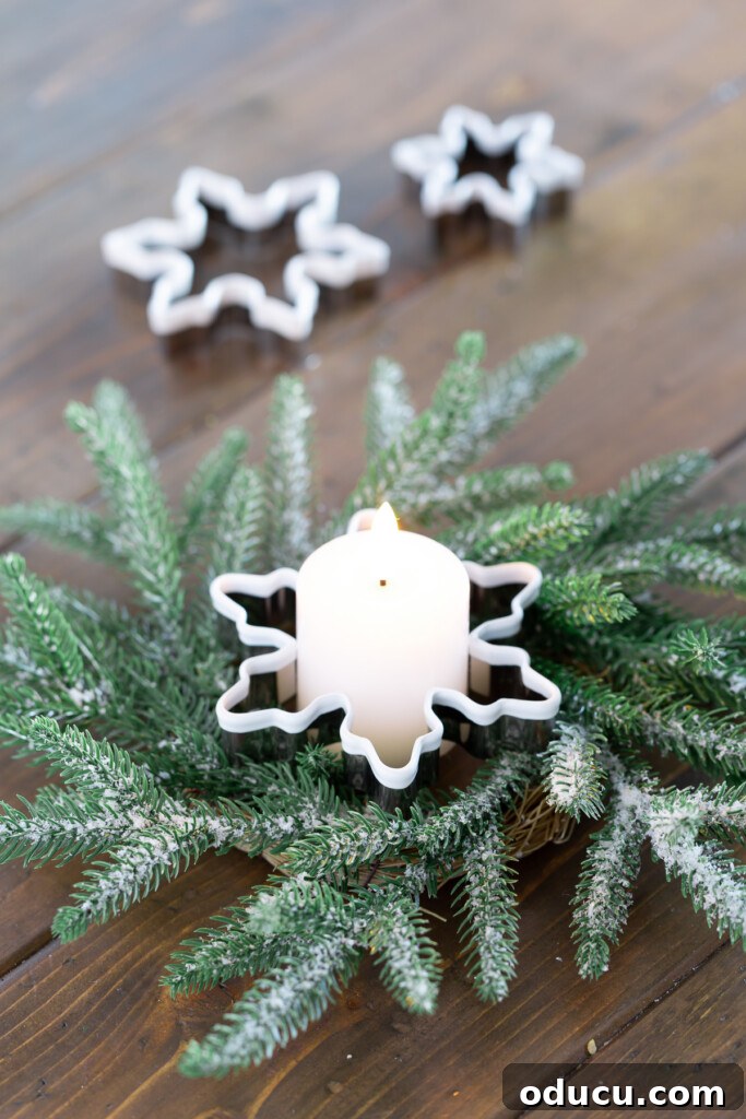 Quick Christmas Home Decor Hacks When Time is Tight 11 Snowflake cookie cutter used to hold a candle on a wreath as a Christmas decoration.
