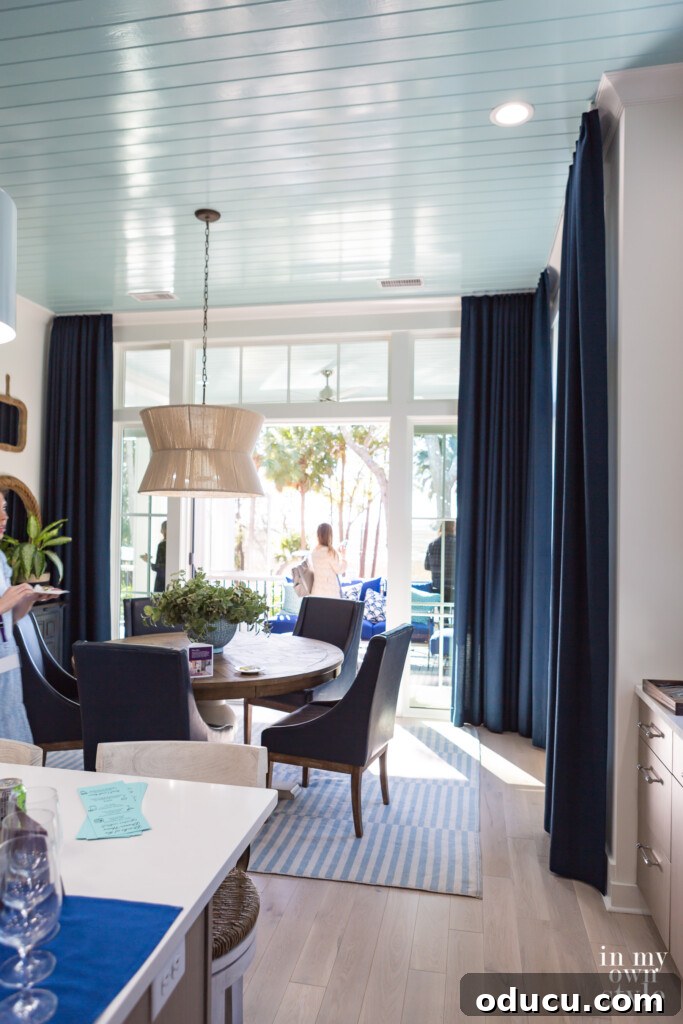 HGTV Dream Home 2020 Revealed 11 The elegant dining room at the HGTV Dream Home 2020, showcasing a large round table, stylish blue leather chairs, and dramatic drapes
