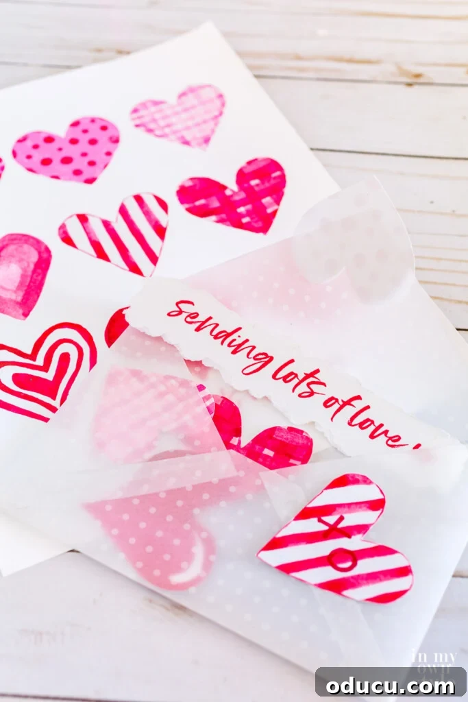 Free printable Valentine envelope filled with pink and red watercolor hearts.