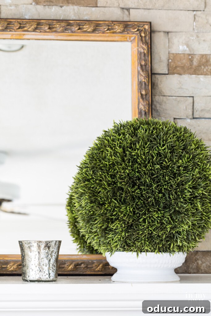 Effortless Home Refresh 2 Mantel with a gold framed mirror, topiary ball and silver votive candle holder, showcasing budget-friendly restyling.