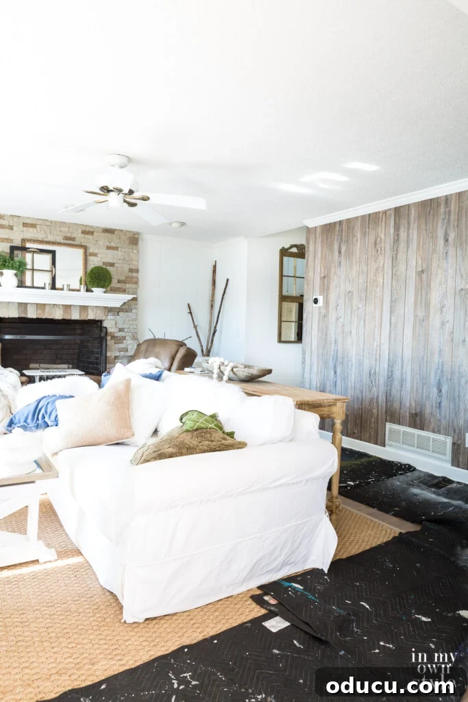 Dramatic Living Room Transformation 9 Stone fireplace and barnwood paneled accent wall, showcasing a harmonious blend of textures