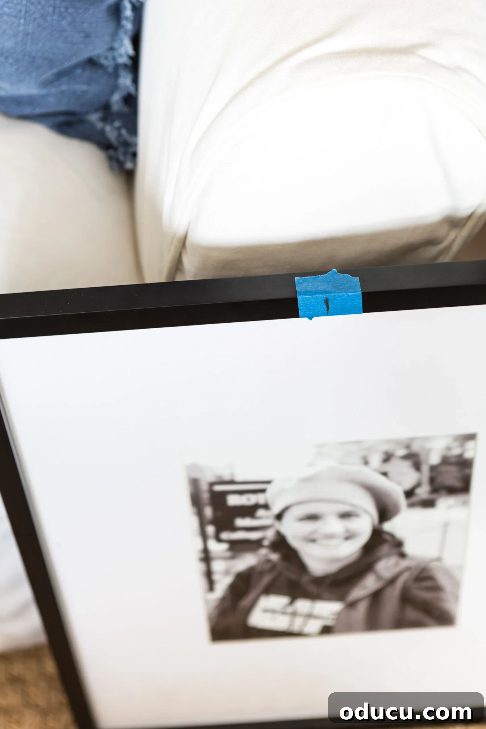 Measuring the frames to fit evenly for a grid style gallery wall, marking the center point on each frame.
