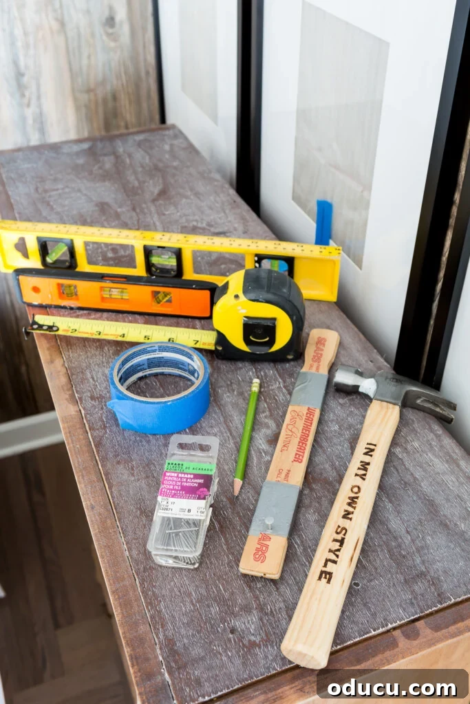 Essential tools needed for hanging a photo gallery wall, including hammer, level, and measuring tape.