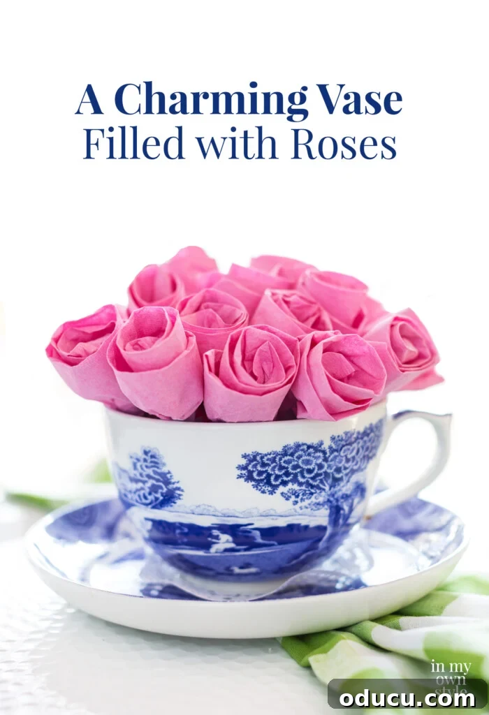 Pink paper napkins made into a dozen roses and placed in a teacup, demonstrating easy DIY paper flower craft.