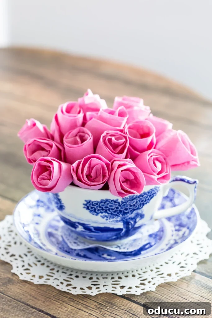Pink paper roses in a blue and white teacup vase, illustrating versatile paper craft ideas.