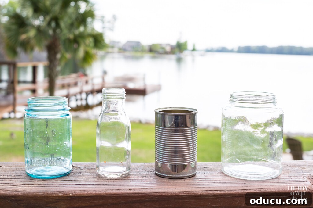 Effortless Chic Patio Umbrella Centerpiece 2 Saved from the recycling bin. Glass jars and a tin can lined up on an outdoor deck railing.