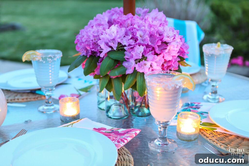 Effortless Chic Patio Umbrella Centerpiece 5 Umbrella patio table centerpiece made using glass bottles. Table set and candles are lit on table.
