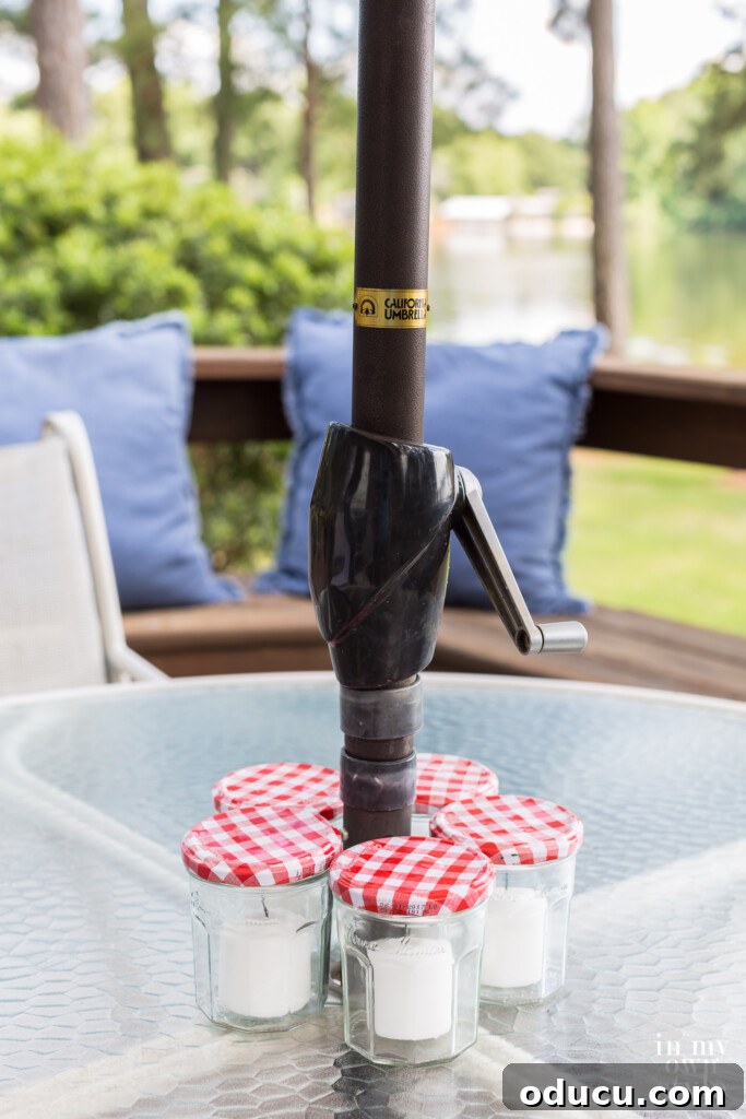 Effortless Chic Patio Umbrella Centerpiece 7 Red and white liddedJelly jar candle centerpiece on outdoor deck.