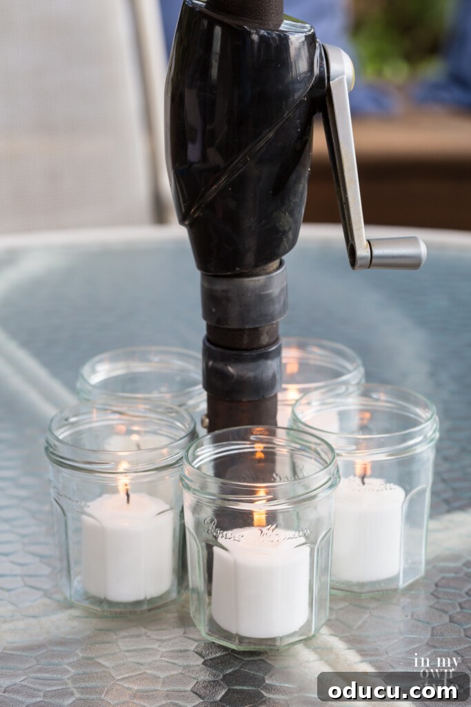 Effortless Chic Patio Umbrella Centerpiece 8 5 jelly jars turned into pretty votive candle holders around a patio tables umbrella pole.