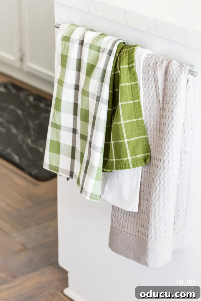 Effortless Summer Style 13 Dishtowels hanging from towel bar in summer decorated kitchen.