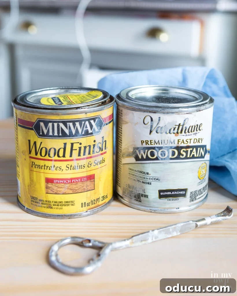Transform Your Wicker Basket into a Stylish Side Table 8 Two cans of wood stain, Minwax Pecan and Varathane Sunbleached, and an opener on a table.