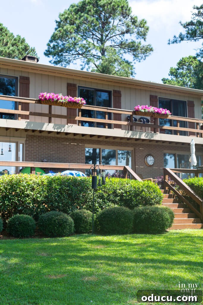Lakeside Deck Rail Planter Boxes 15 Fake pink flowers in deck railing planters on house.