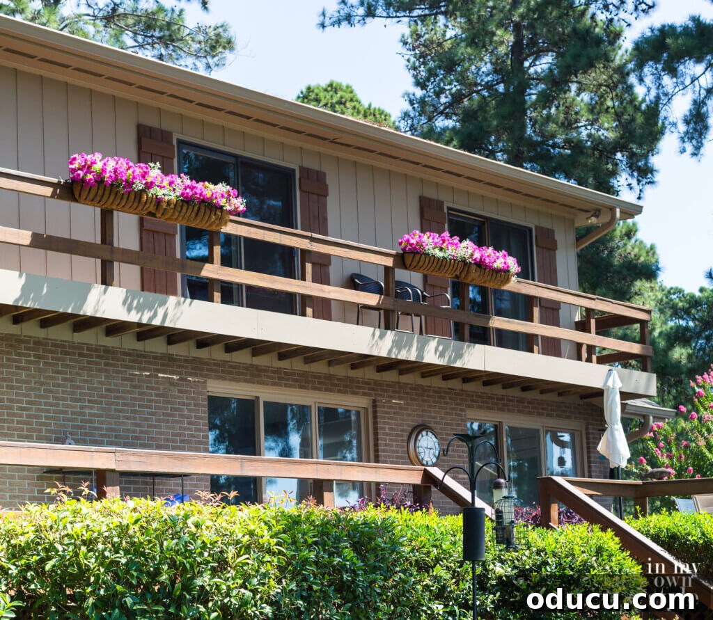 Lakeside Deck Rail Planter Boxes 16 Fake pink flowers in deck railing planters on house.
