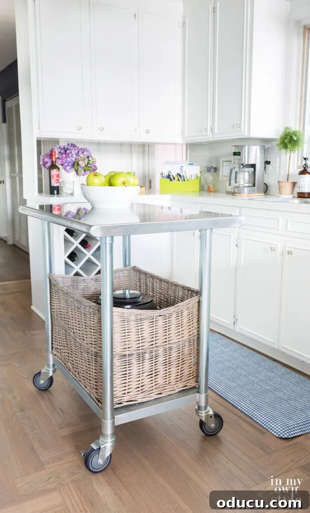 Cultivating Your Creative Sanctuary 2 Movable metal rolling island in a small white kitchen, showcasing its versatility and compact design.