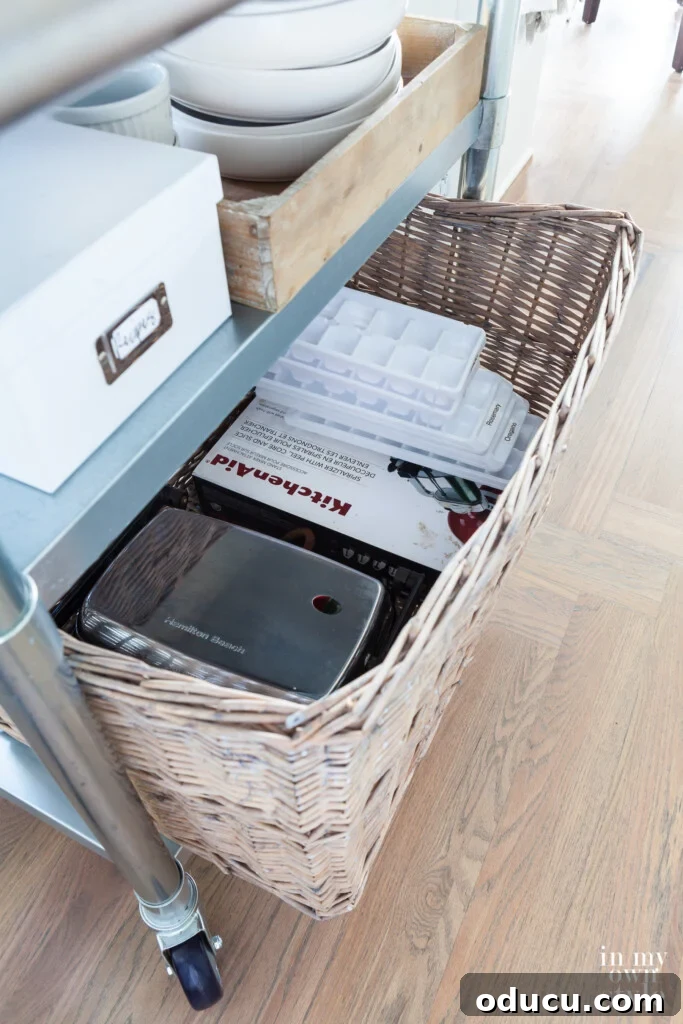 Cultivating Your Creative Sanctuary 11 A large wicker basket on a metal rolling kitchen island filled with least used kitchen tools, organized efficiently.
