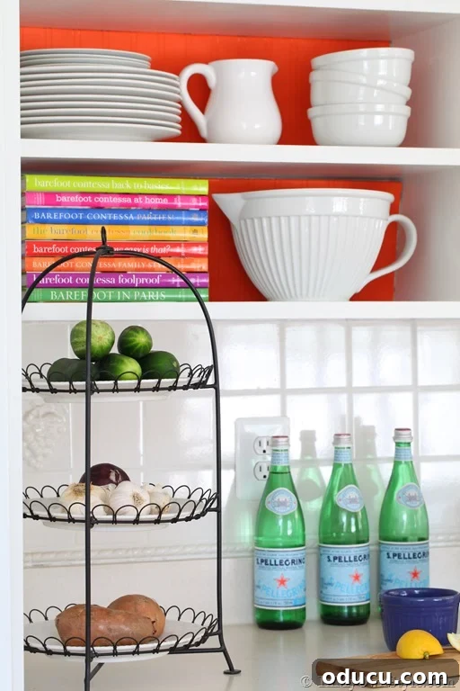 Instant Summer Room Makeover 6 An open kitchen shelf decorated with a colorful cardboard backdrop, demonstrating how to add vibrant backdrops to open shelving.