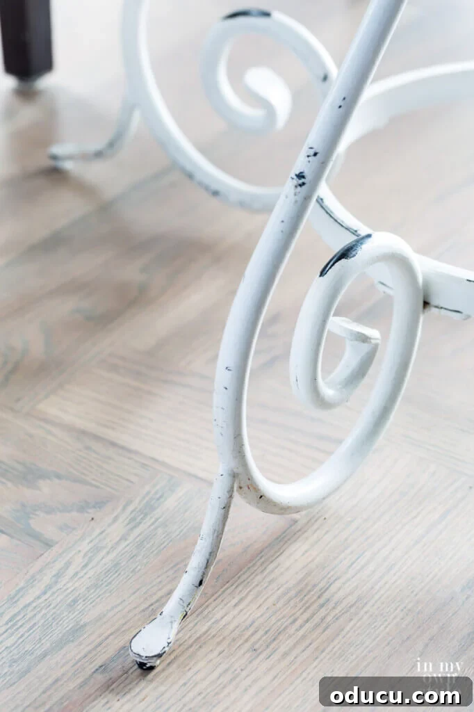 Score Free Fabric for Stunning Home Decor 11 White painted metal table legs showing worn areas, revealing the black wrought iron underneath, creating a charming vintage look perfect for fall decor.