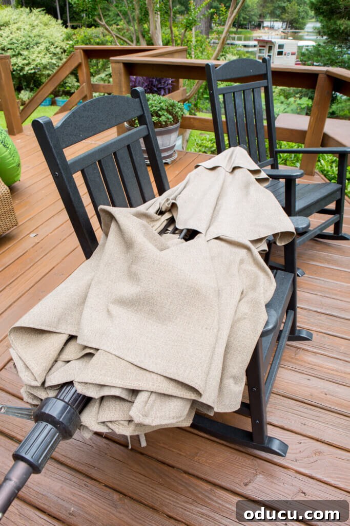 Score Free Fabric for Stunning Home Decor 3 Broken patio umbrella resting on two deck rocking chairs, illustrating its unusable state.