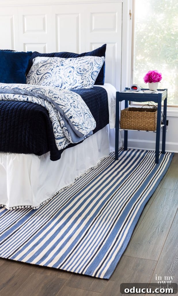 Upcycle Household Items for Breathtaking Decor 17 Blue and white bedroom with blue and shite striped area rug over dark hardwood floor.