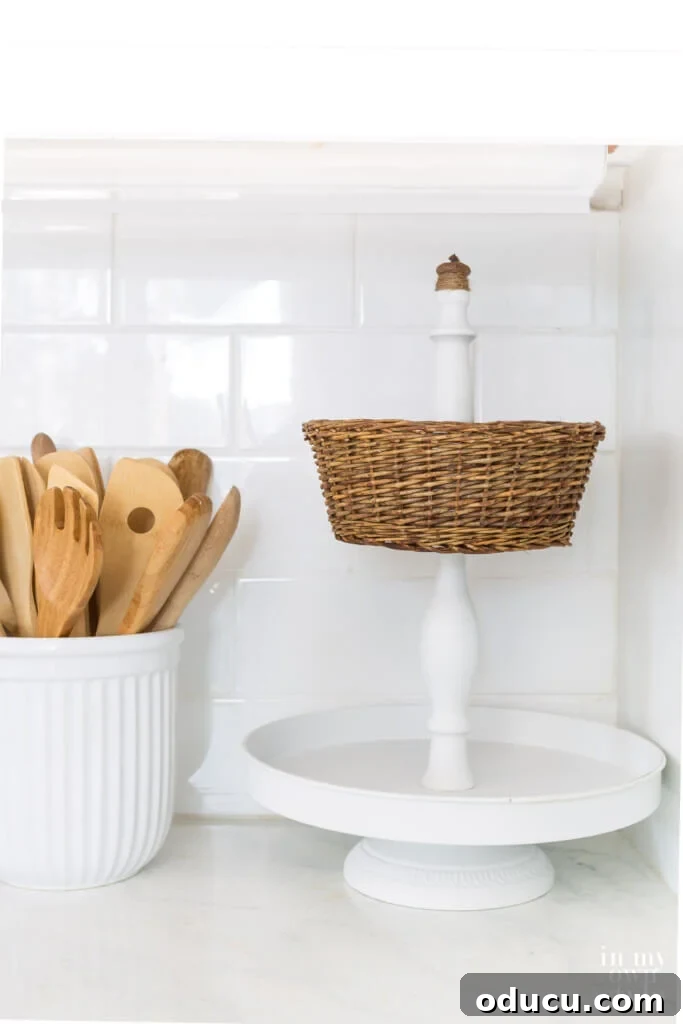 Crafting a Dual-Level Kitchen Storage Stand 13 White metal 2 tiered stand with wicker basket on kitchen counter. The final 2-tier stand with a wicker basket, holding various fruits on a kitchen counter.