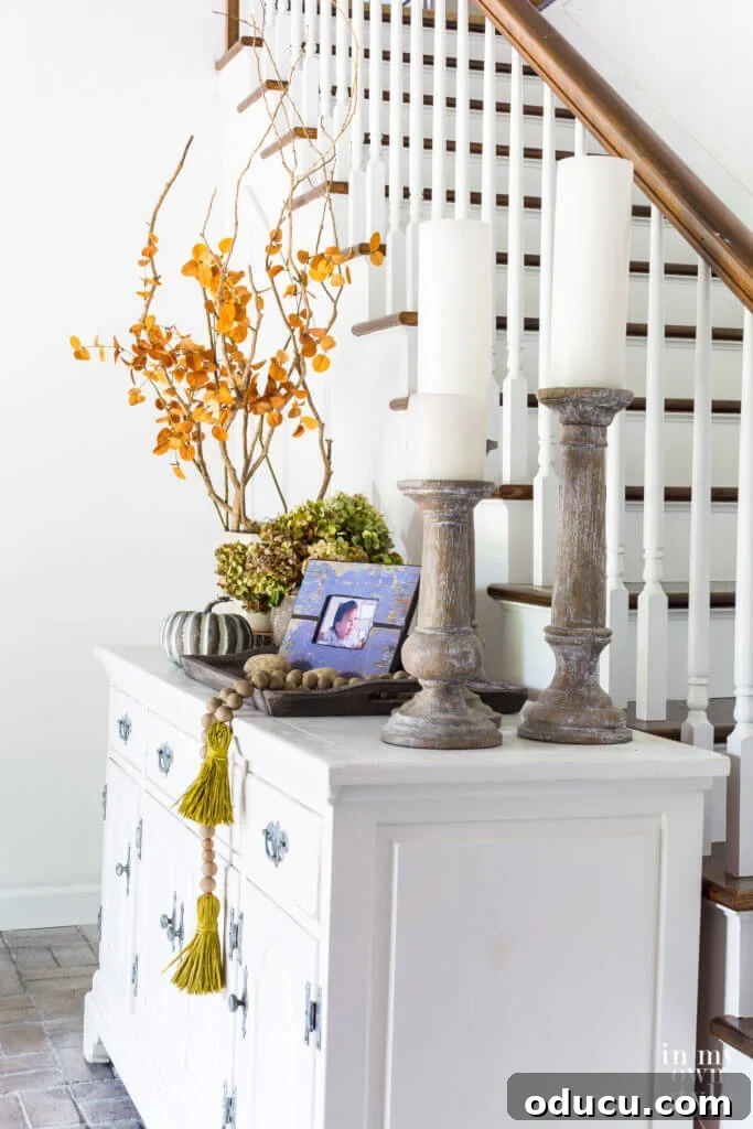 Entryway Upgrade: The Dresser Solution 17 Sideboard in entryway of house decorated for fall using various heights of decor for impact.