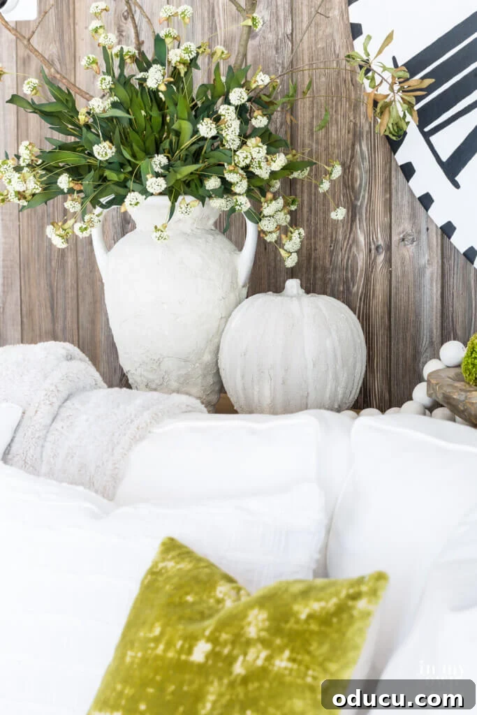 Autumn's Embrace: Natural Decor for Your Living Space 4 Plaster covered vase and pumpkin on sofa table.