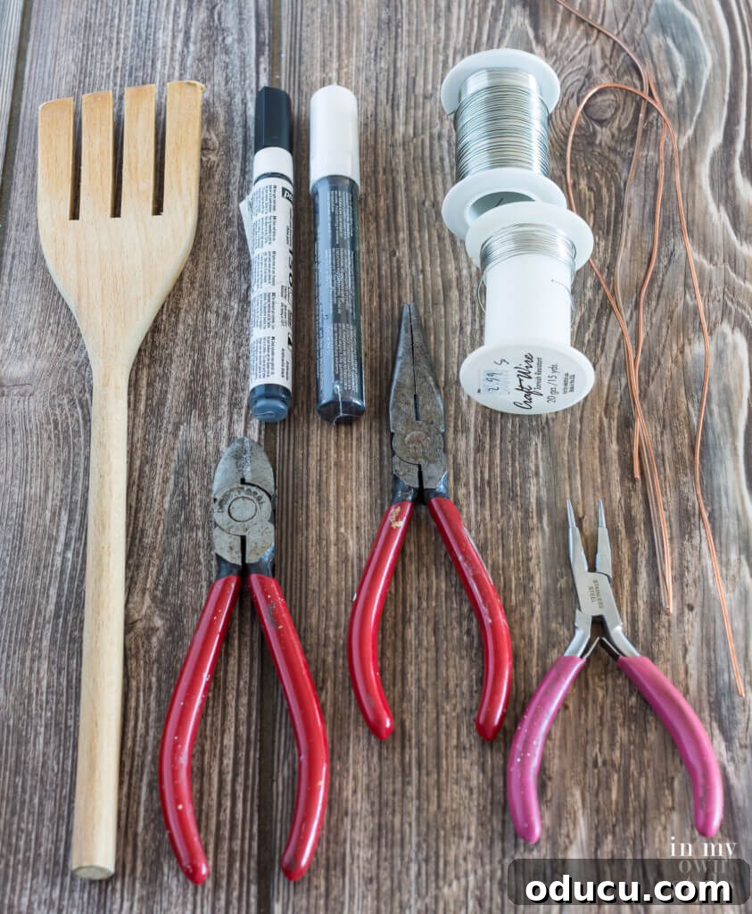 A flat lay photograph showcasing all the essential supplies required to make DIY ceramic jar lid photo holders, including a decorative lid, wire, pliers, and a shaping dowel.