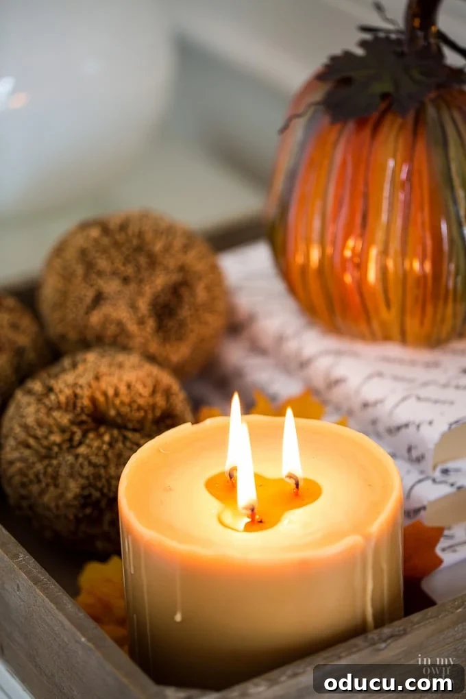 Decorating for fall with candles and pumpkins, creating a warm and inviting atmosphere.